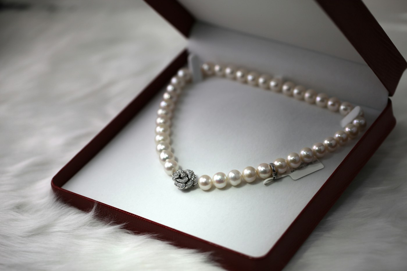 Small jewelry gift box with simple earrings on a bedside table in natural morning light